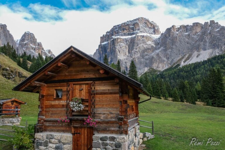 Cabanon fleuri devant les imposants sommets rocheux des Dolomites