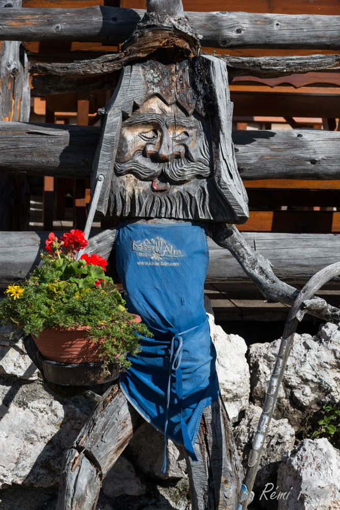 Sculpture en bois tenant un pot de fleur