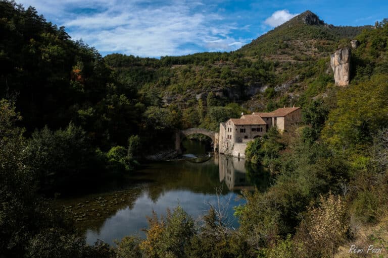 Pont en pierre au dessus d'une rivière qui serpentent dans les grands causses