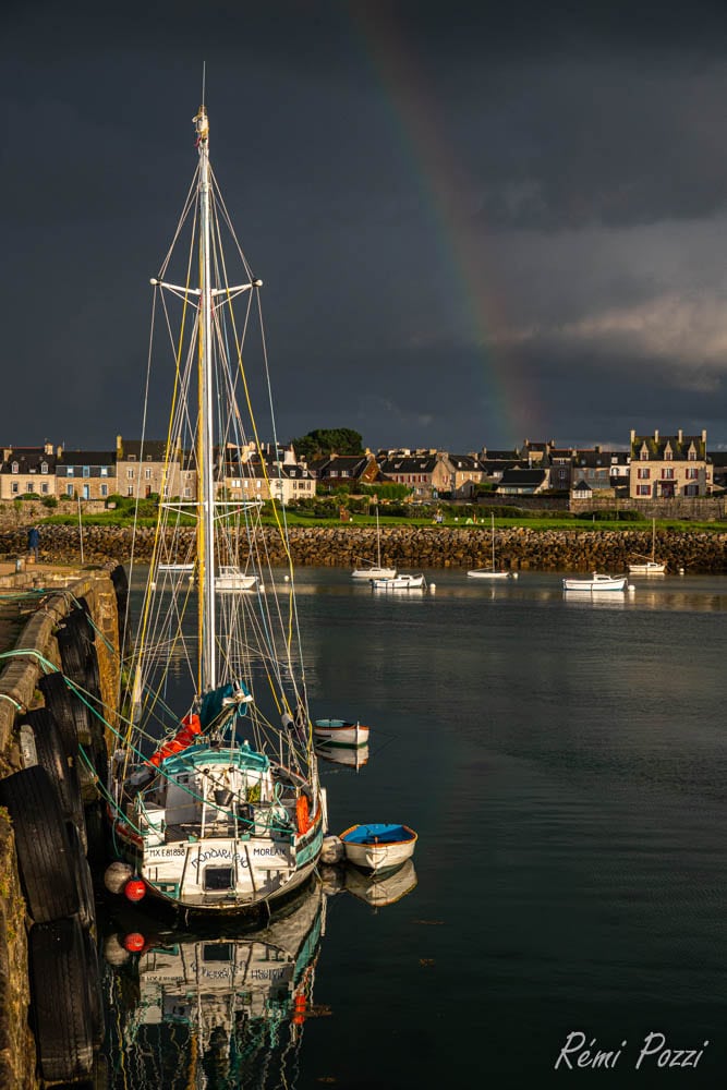 Bateau de pêche devant un arc en ciel