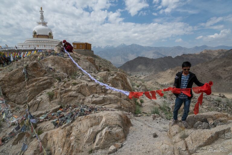 Indiens qui accrochent des drapeaux de prière à la montagne