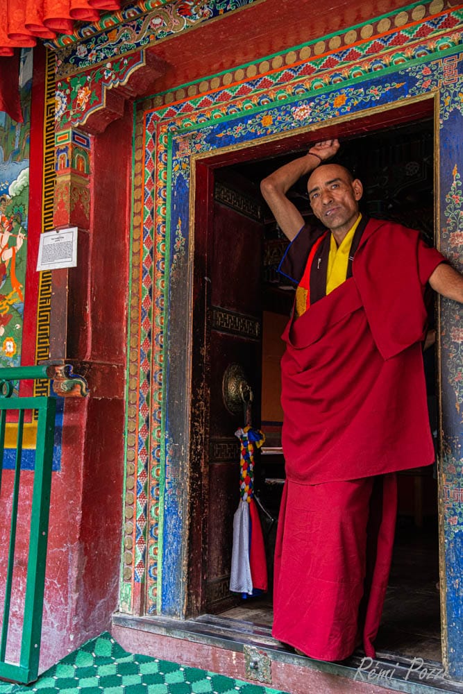 Moine bouddhiste devant l'entrée d'un temple