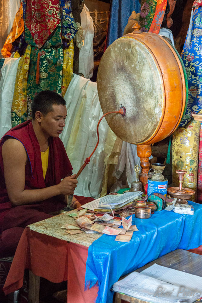 Moine bouddhiste qui tape sur un gong