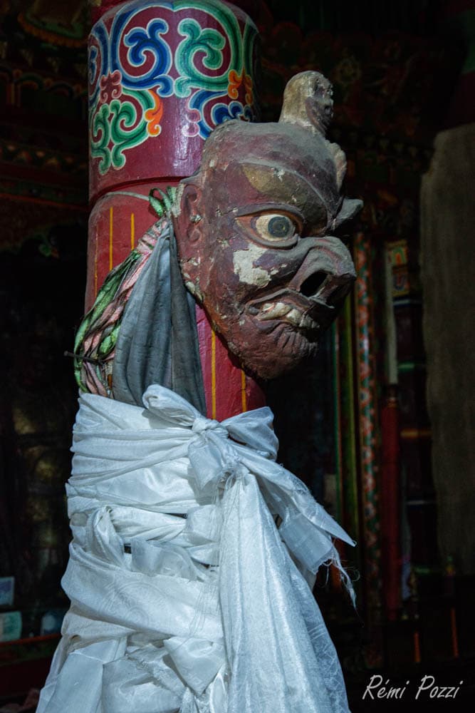 Masque en bois accroché à une colonne d'un temple bouddhiste